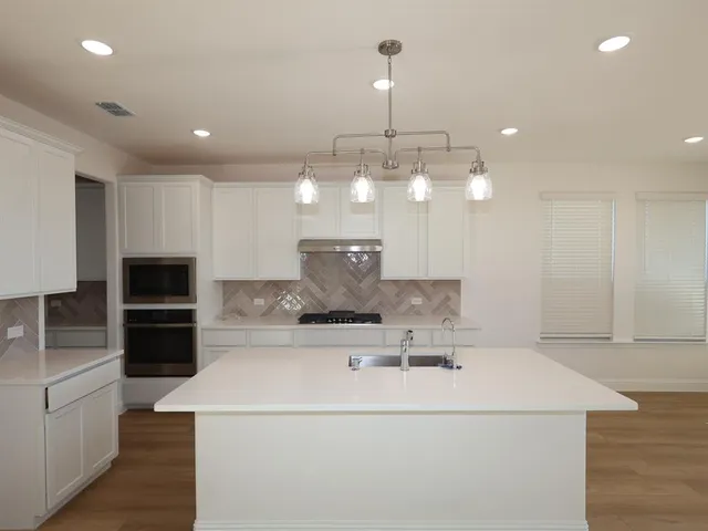 a view of a kitchen with a sink and stainless steel appliances