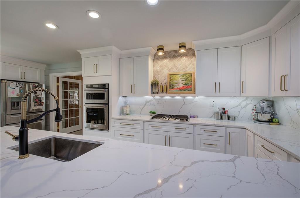 566 Old Grade Road Resaca, GA 30735 - Photo 11 of 48 a kitchen with stainless steel appliances a stove sink and cabinets