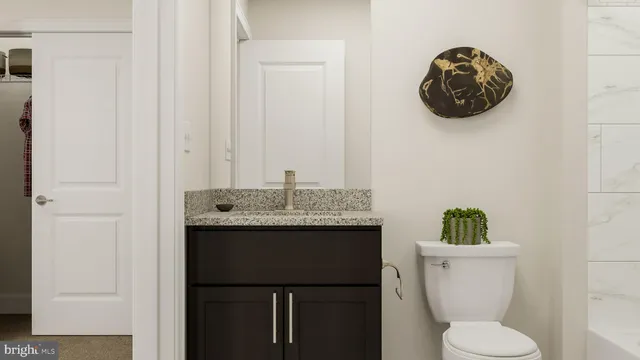 a bathroom with a sink a toilet and a mirror