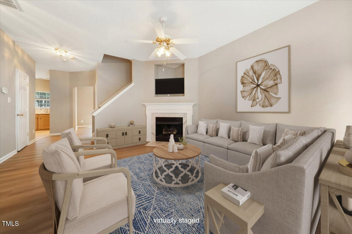 5305 Corinthian Way Raleigh, NC 27607 - Photo 4 of 21 a living room with furniture a fireplace and a chandelier