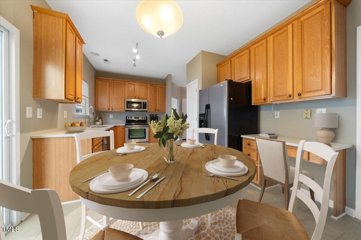 5305 Corinthian Way Raleigh, NC 27607 - Photo 7 of 21 a kitchen with granite countertop a table chairs microwave and cabinets