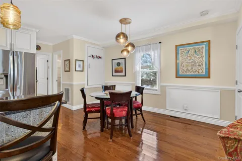 a kitchen with stainless steel appliances kitchen island granite countertop a dining table chairs and white cabinets
