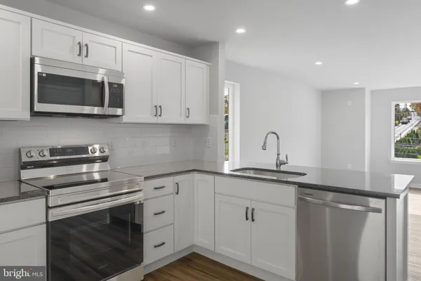 a kitchen with white cabinets and stainless steel appliances