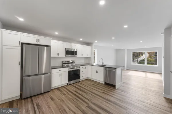 a kitchen with a refrigerator stove and wooden floor