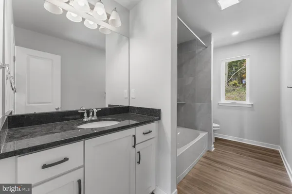 a bathroom with a granite countertop sink a vanity and mirror