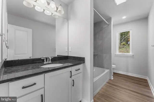 a bathroom with a granite countertop sink a vanity and mirror