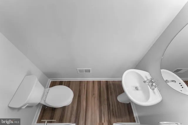 a bathroom with a toilet a sink and mirror