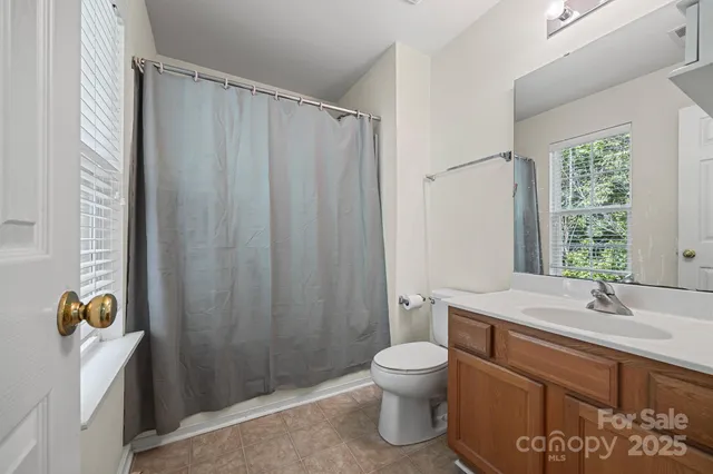 a bathroom with a sink a toilet and shower curtain