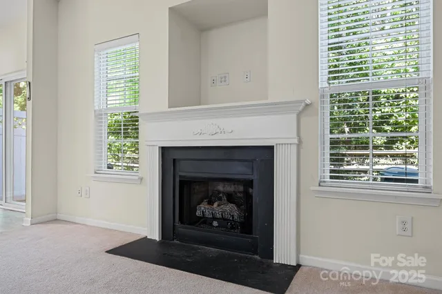 a living room with a fireplace and windows