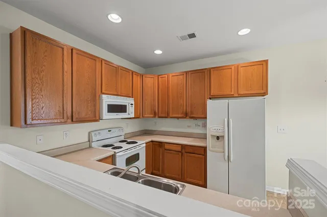 a kitchen with stainless steel appliances granite countertop a sink refrigerator and microwave