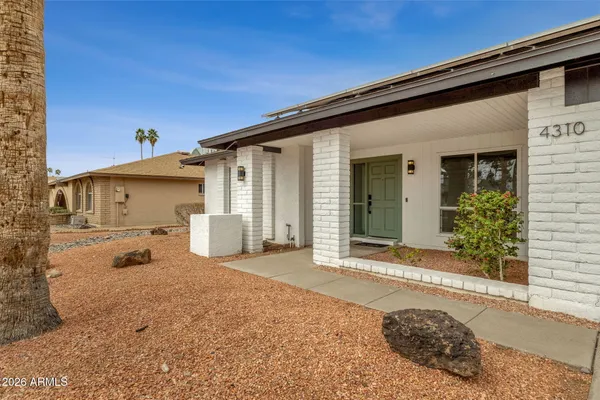 a front view of a house with snow on table and chairs