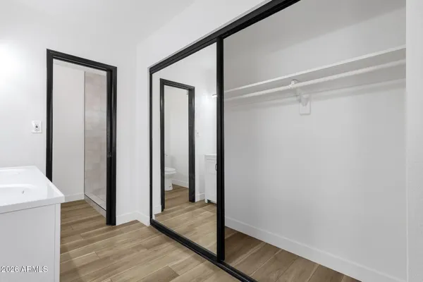 a spacious bathroom with a double vanity sink a mirror and a toilet