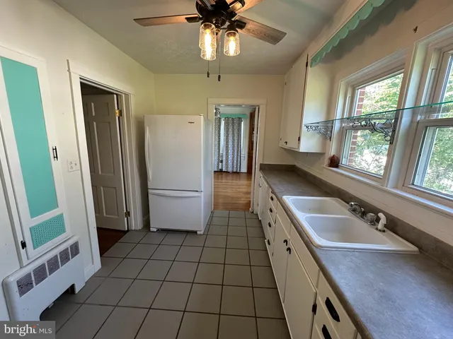 a bathroom with a granite countertop sink a toilet a mirror and shower