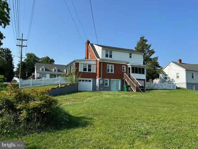 a front view of a house with a yard and trees