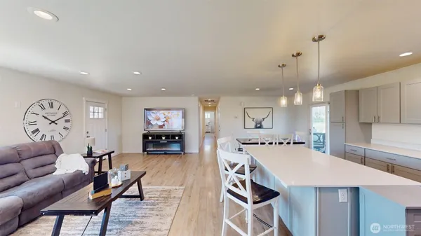 a living room with furniture a table and kitchen chandelier