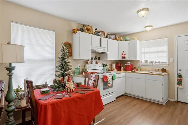 a living room with furniture kitchen view and a flat screen tv