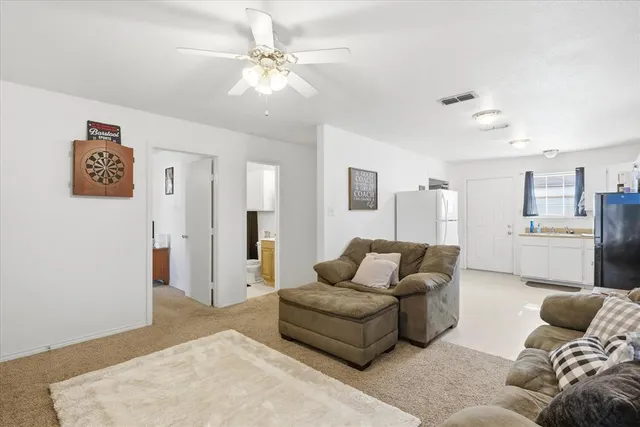 a kitchen with a refrigerator a stove top oven a sink and white cabinets
