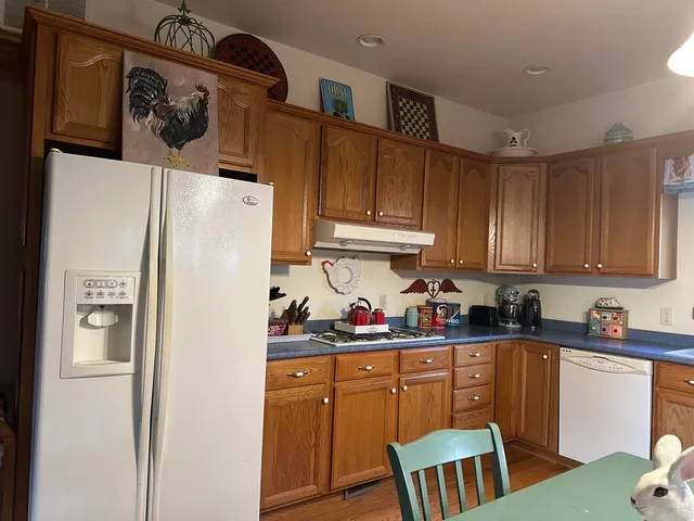 a kitchen with stainless steel appliances granite countertop a refrigerator and a stove top oven