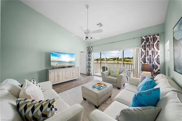 a living room with furniture a ceiling fan and a rug