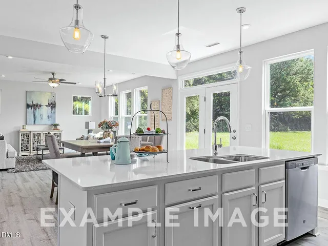 a kitchen with sink a window and chairs