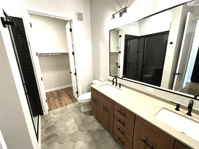 a bathroom with a double vanity sink a mirror and a bathtub