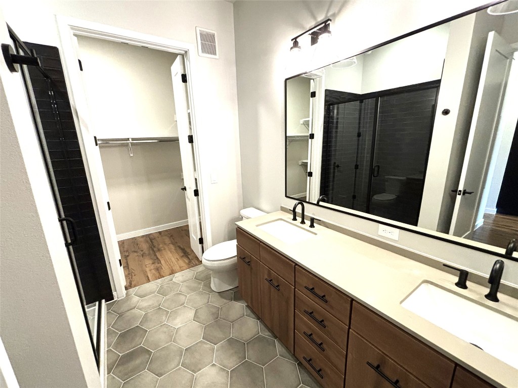 4510 Terry-O Lane, Unit 406 Austin, TX 78745 - Photo 15 of 34 a bathroom with a double vanity sink a mirror and a bathtub