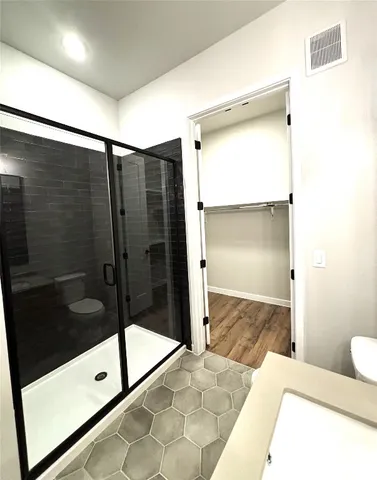 a bathroom with a glass shower door and a sink