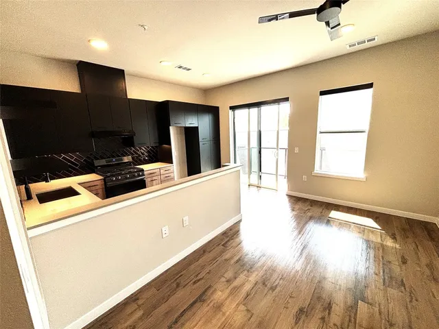 a view of a kitchen with furniture and wooden floor