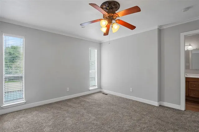 an empty room with closet and a chandelier fan