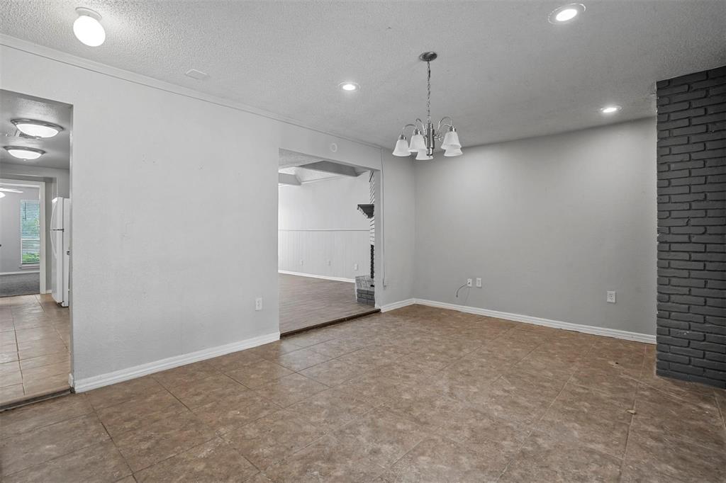 2156 Fleur De Lis Court Arlington, TX 76012 - Photo 7 of 16 an empty room with chandelier fan and kitchen view