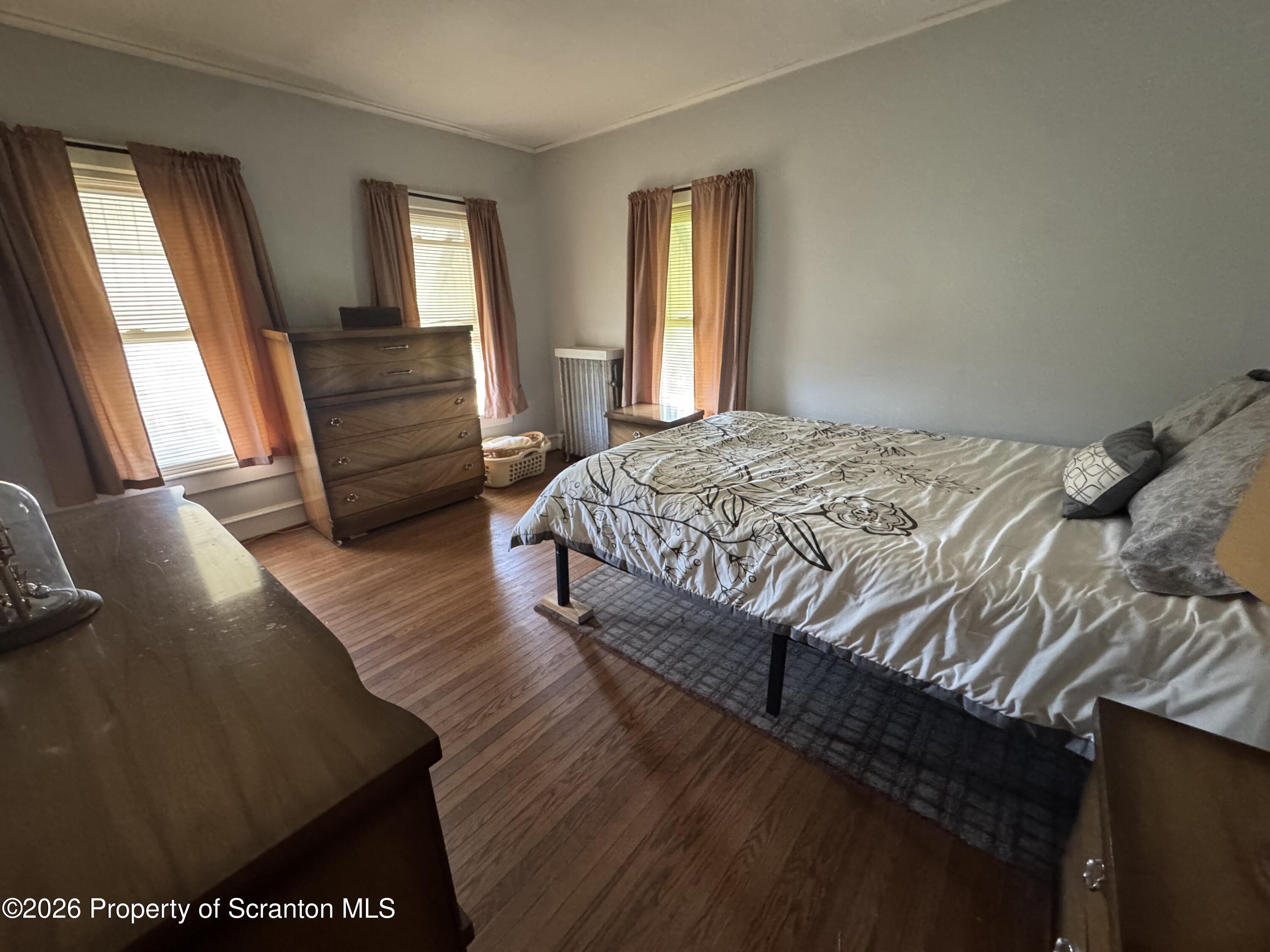 409 East Warren Street Dunmore, PA 18512 - Photo 12 of 19 a bedroom with a bed and wooden floor