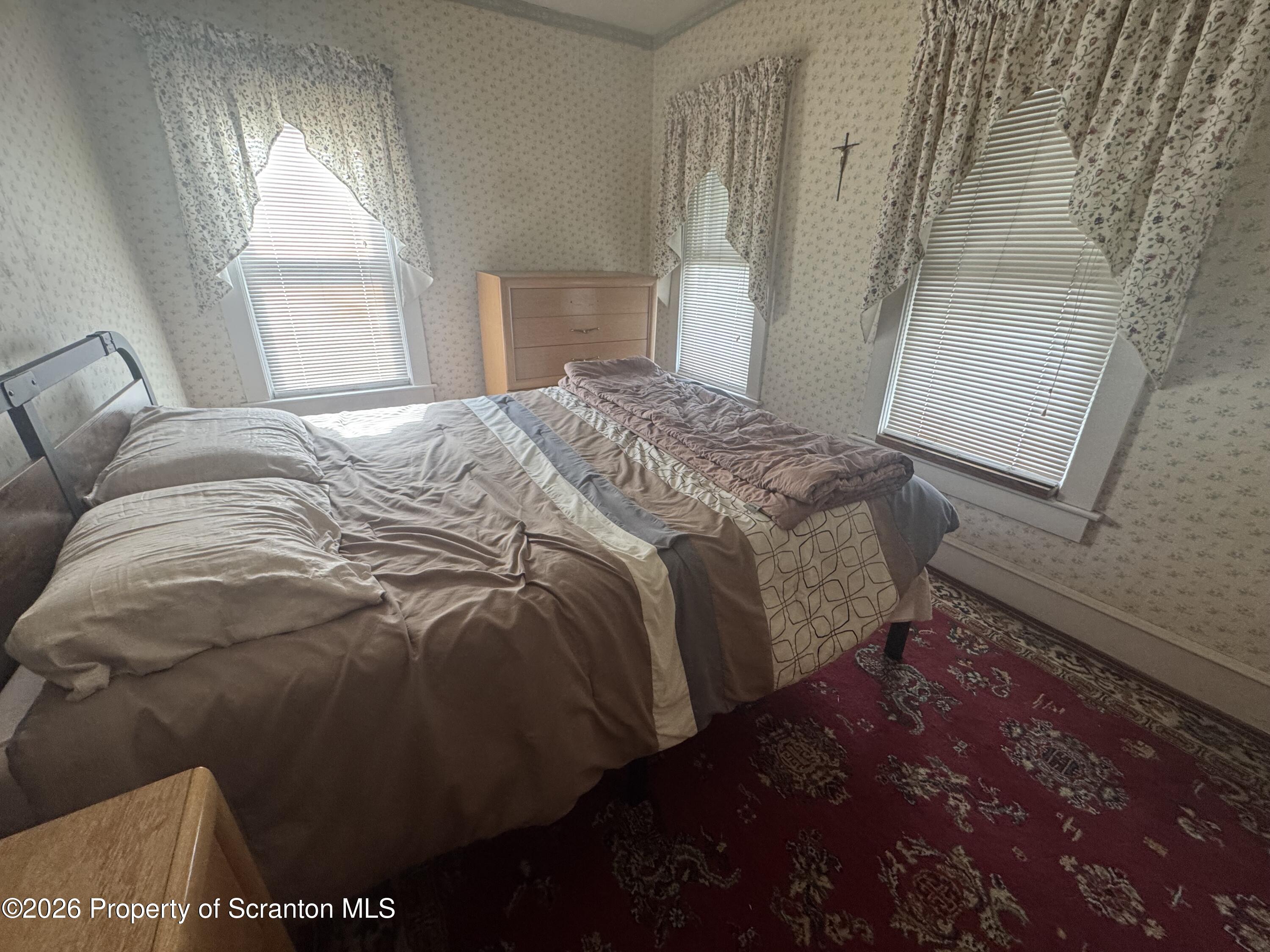 409 East Warren Street Dunmore, PA 18512 - Photo 14 of 19 a bed sitting in a bedroom next to a window