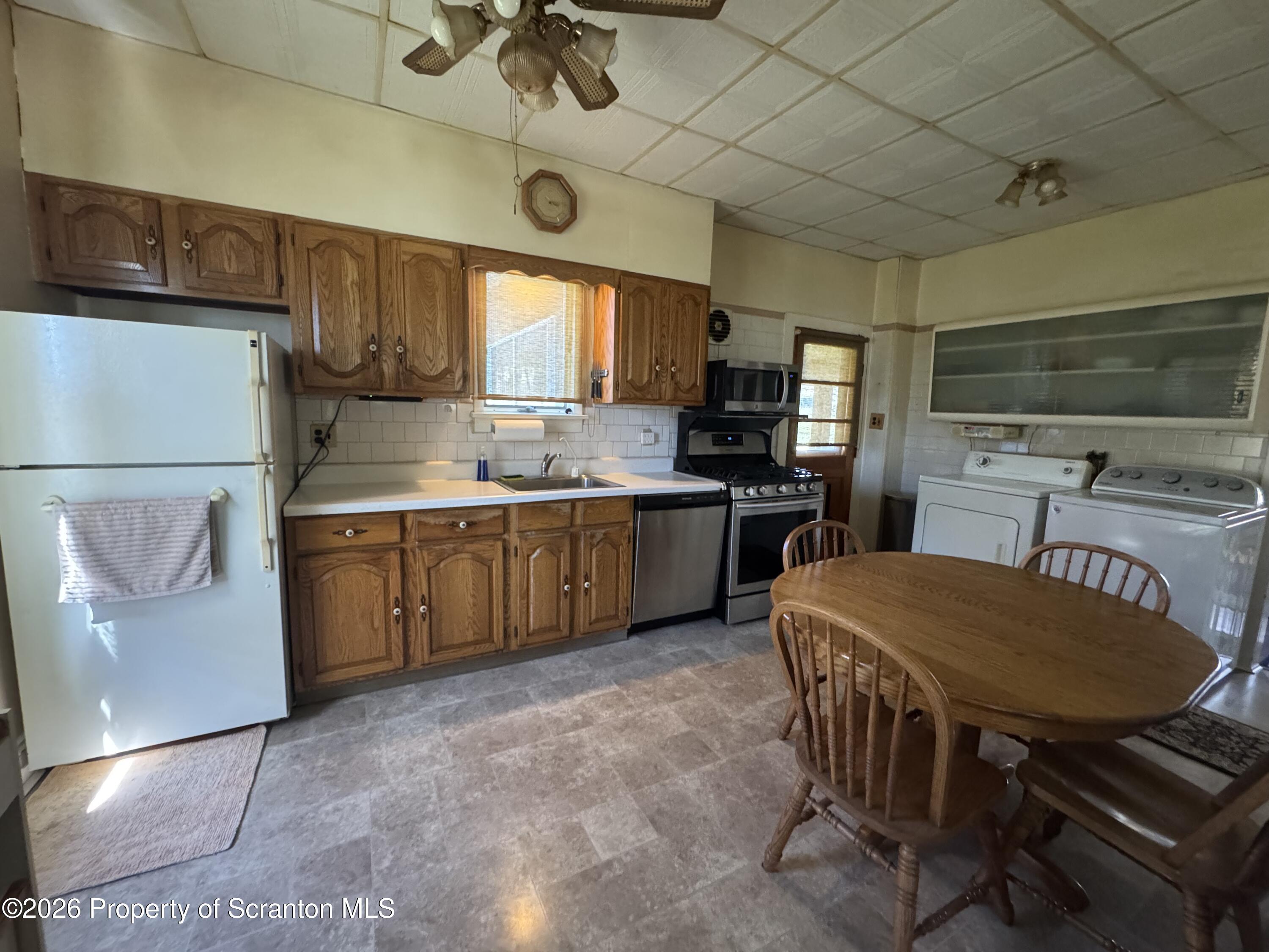 409 East Warren Street Dunmore, PA 18512 - Photo 6 of 19 a kitchen with a sink a stove and chairs