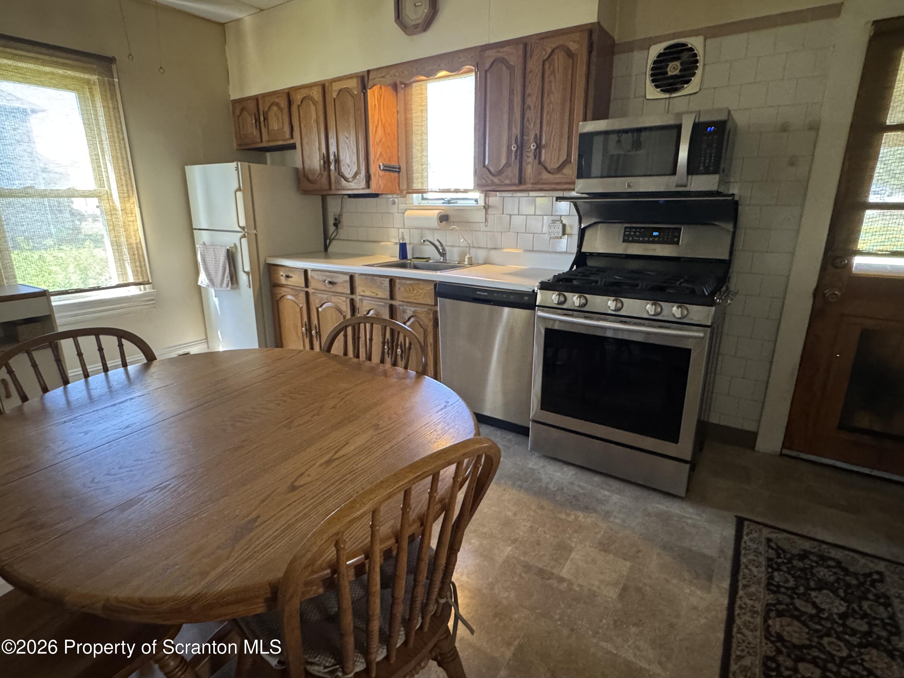 409 East Warren Street Dunmore, PA 18512 - Photo 7 of 19 a kitchen with stainless steel appliances granite countertop a stove a sink and a microwave