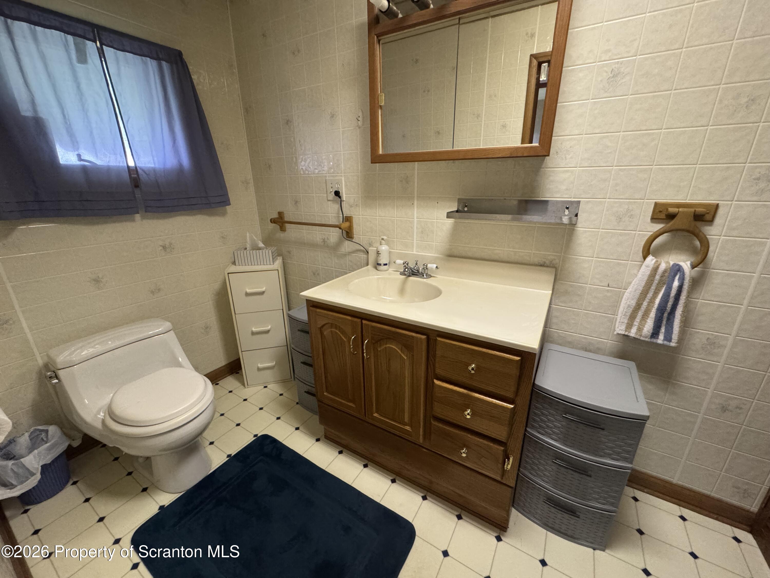 409 East Warren Street Dunmore, PA 18512 - Photo 9 of 19 a bathroom with a sink a toilet and mirror