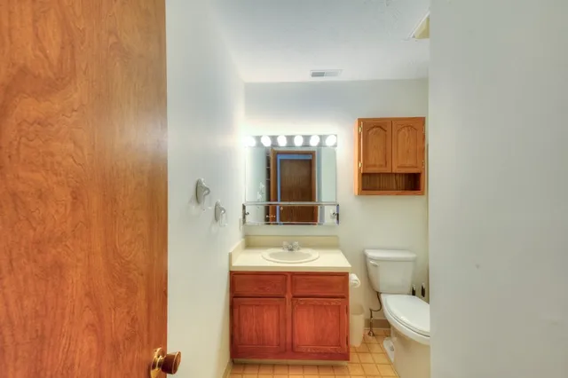 a bathroom with a sink a toilet and mirror