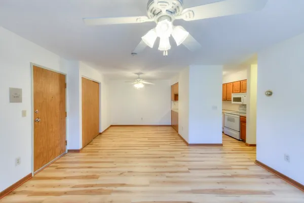 a view of an empty room with wooden floor and a window