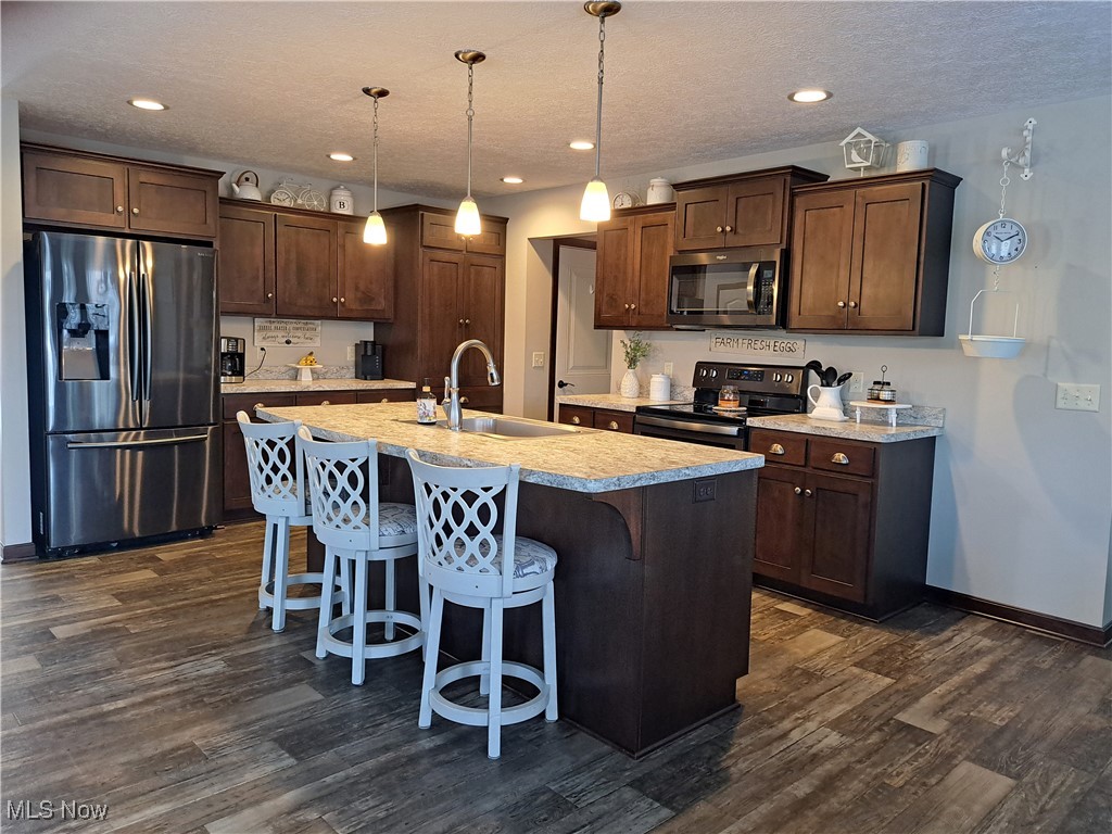 63877 Larrick Ridge Road Cambridge, OH 43725 - Photo 25 of 43 Kitchen with stainless steel appliances, LVT flooring, island with sink, and pendant lighting