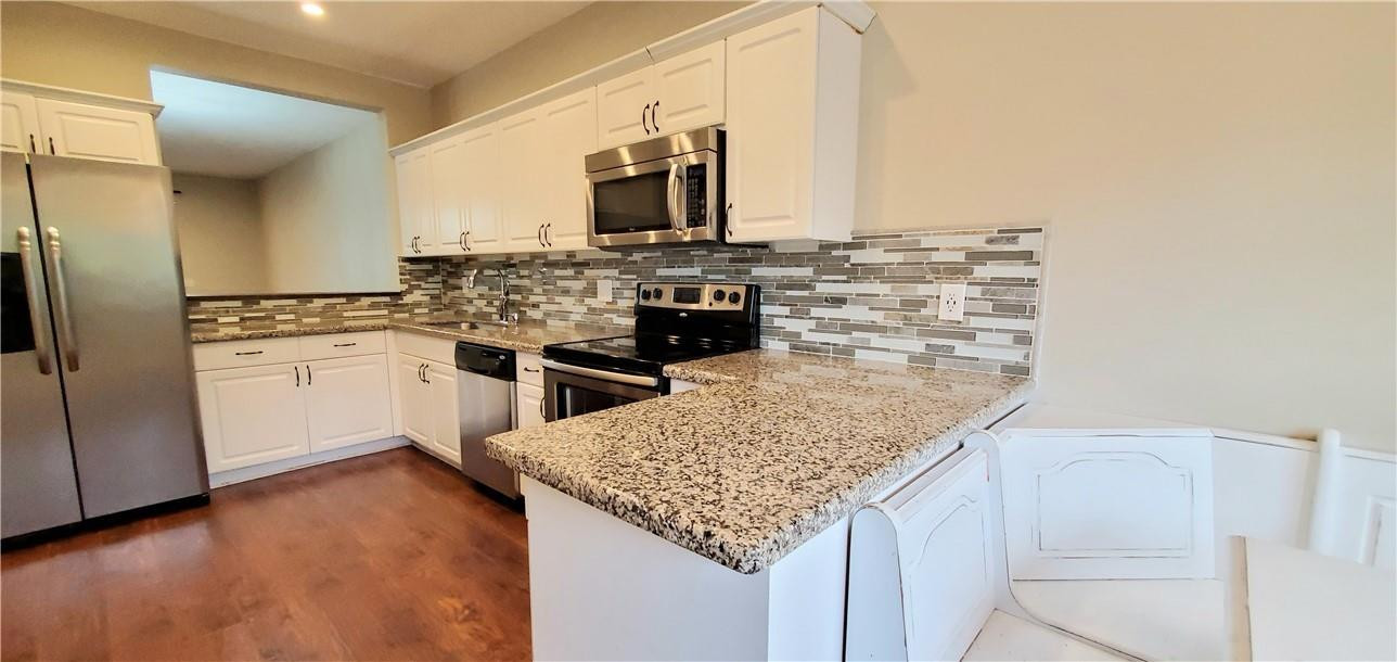 6823 Via Regina Boca Raton, FL 33433 - Photo 3 of 26 a kitchen with stainless steel appliances granite countertop a sink and cabinets