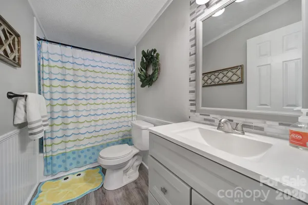 a bathroom with a granite countertop toilet sink and mirror