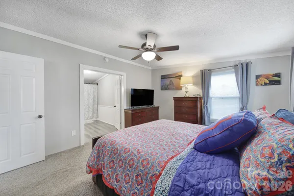 a bedroom with a large bed and a chandelier