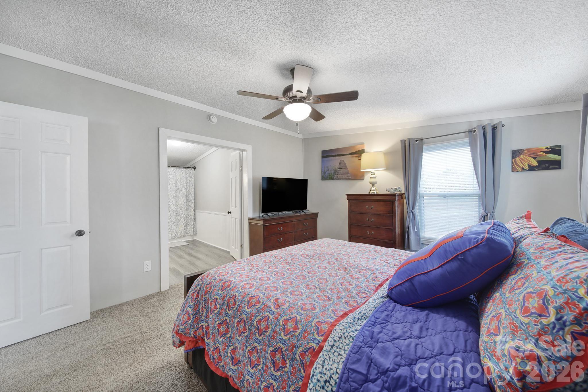 3840 Sherer Road Sharon, SC 29742 - Photo 18 of 30 a bedroom with a large bed and a chandelier