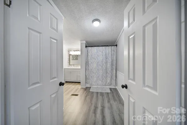 a view of a hallway with wooden floor and staircase