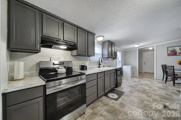a kitchen with stainless steel appliances granite countertop a sink stove and cabinets