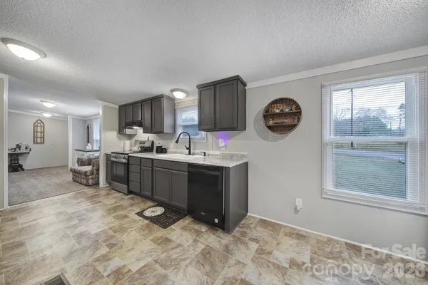 a kitchen with stainless steel appliances granite countertop a stove a sink and a refrigerator with wooden floor