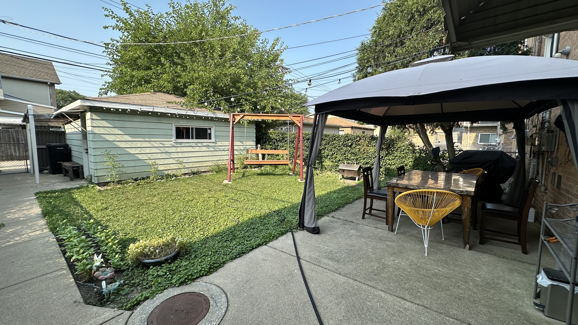 6118 West Gunnison Street, Unit 1 Chicago, IL 60630 - Photo 11 of 11 a view of a backyard with table and chairs under an umbrella