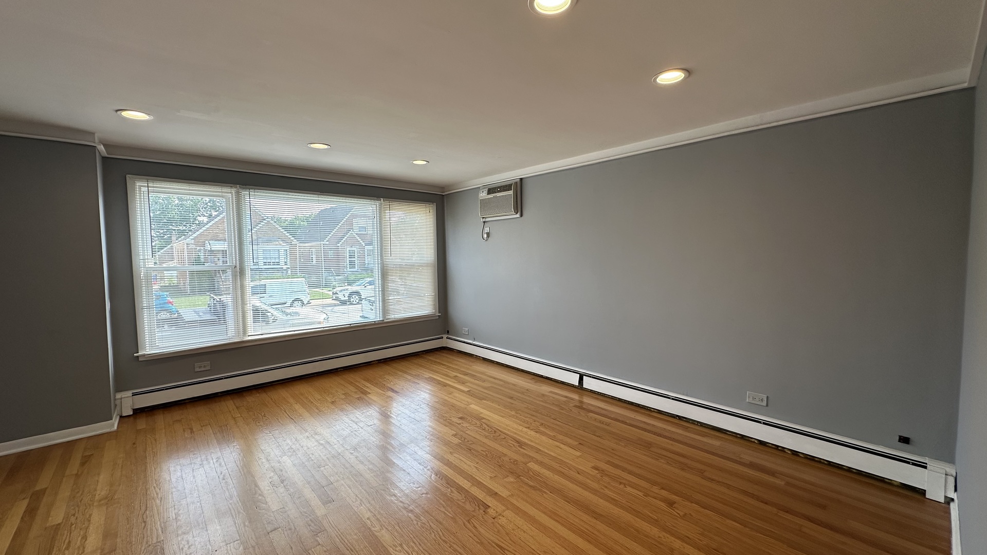 6118 West Gunnison Street, Unit 1 Chicago, IL 60630 - Photo 3 of 11 an empty room with wooden floor and windows