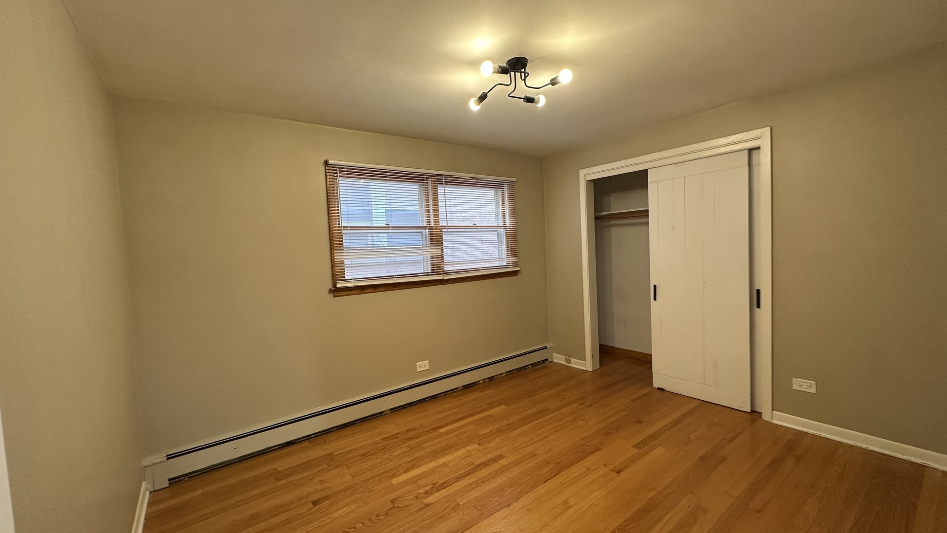 6118 West Gunnison Street, Unit 1 Chicago, IL 60630 - Photo 6 of 11 a view of empty room with a window and wooden floor