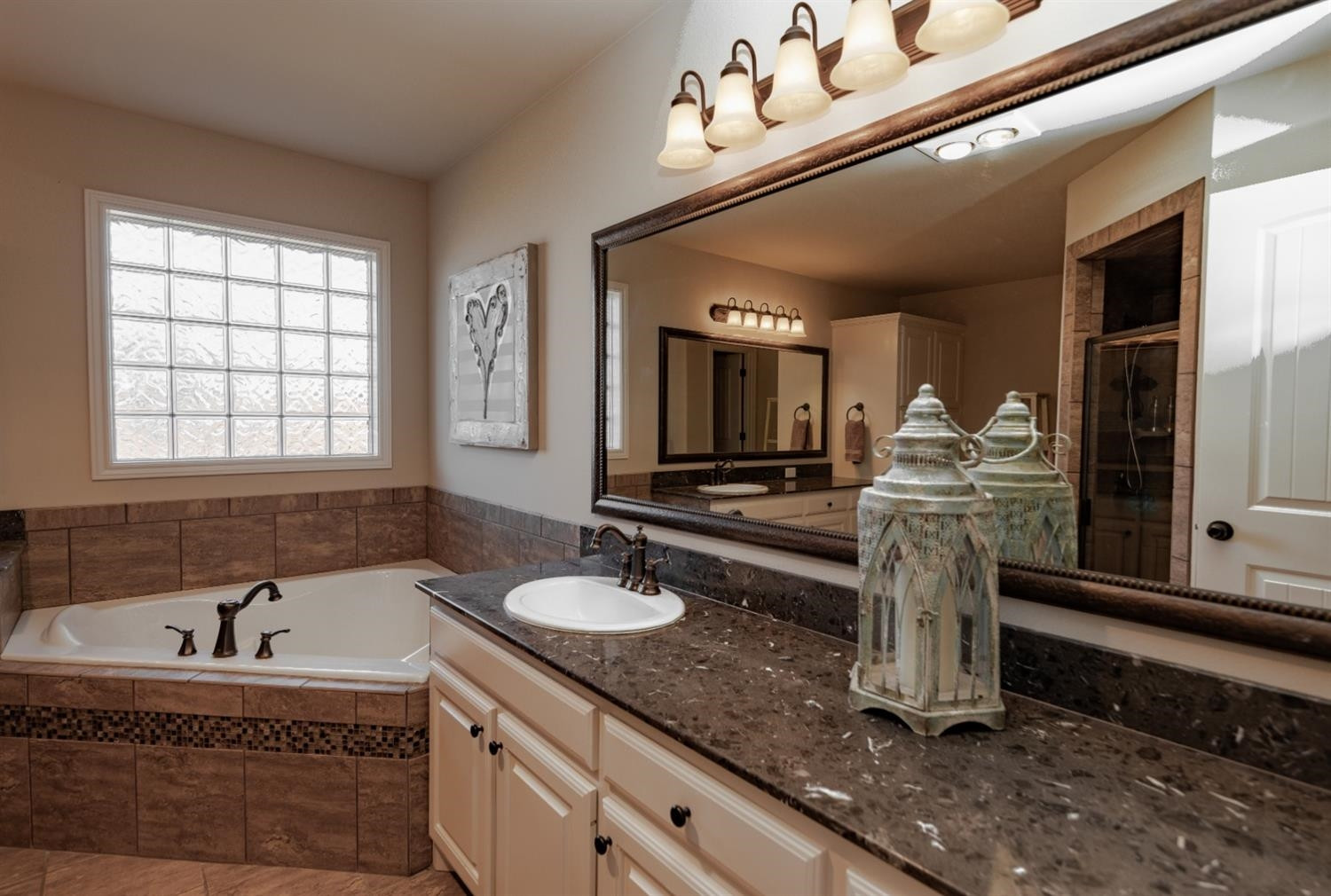 4110 124th Street Lubbock, TX 79423 - Photo 15 of 32 a bathroom with a tub sink and mirror
