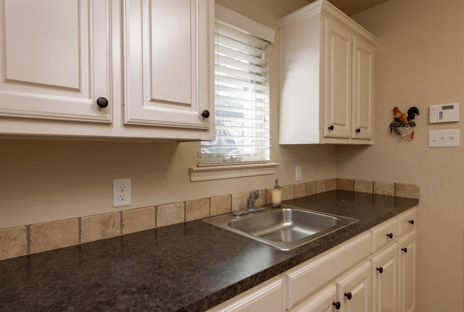 4110 124th Street Lubbock, TX 79423 - Photo 25 of 32 a kitchen with granite countertop a sink and white cabinets